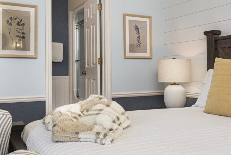 queen bed white lamp and view of bathroom