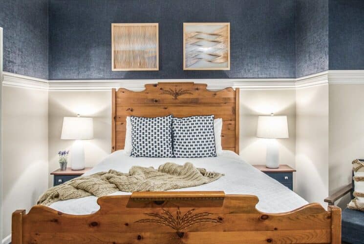 queen bed against blue and tan wall