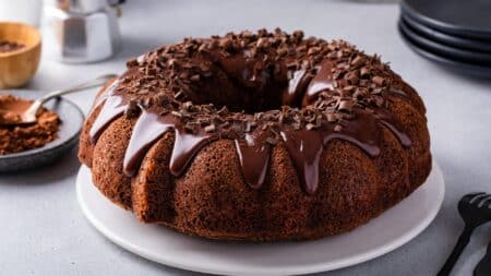 round chocolate cake with glossy fudge glaze and sprinkles on top