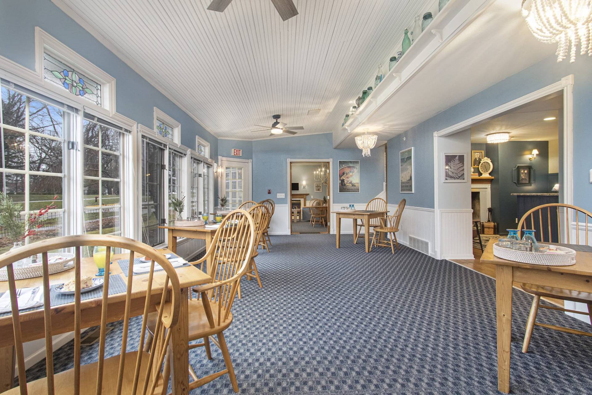 wood table and chairs in dining room with blue walls and blue carpet.