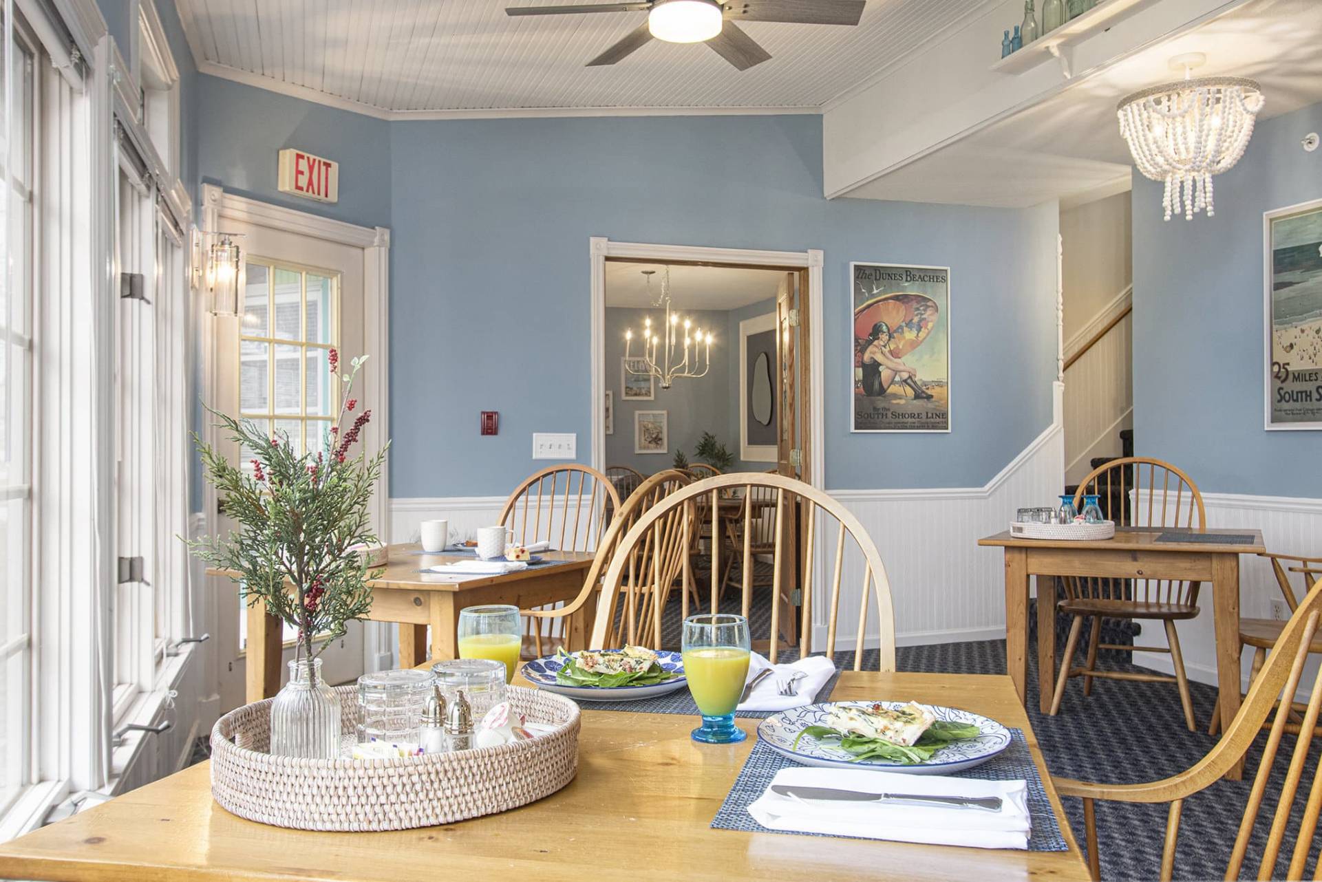 wood table and chairs in dining room with blue walls and blue carpet.