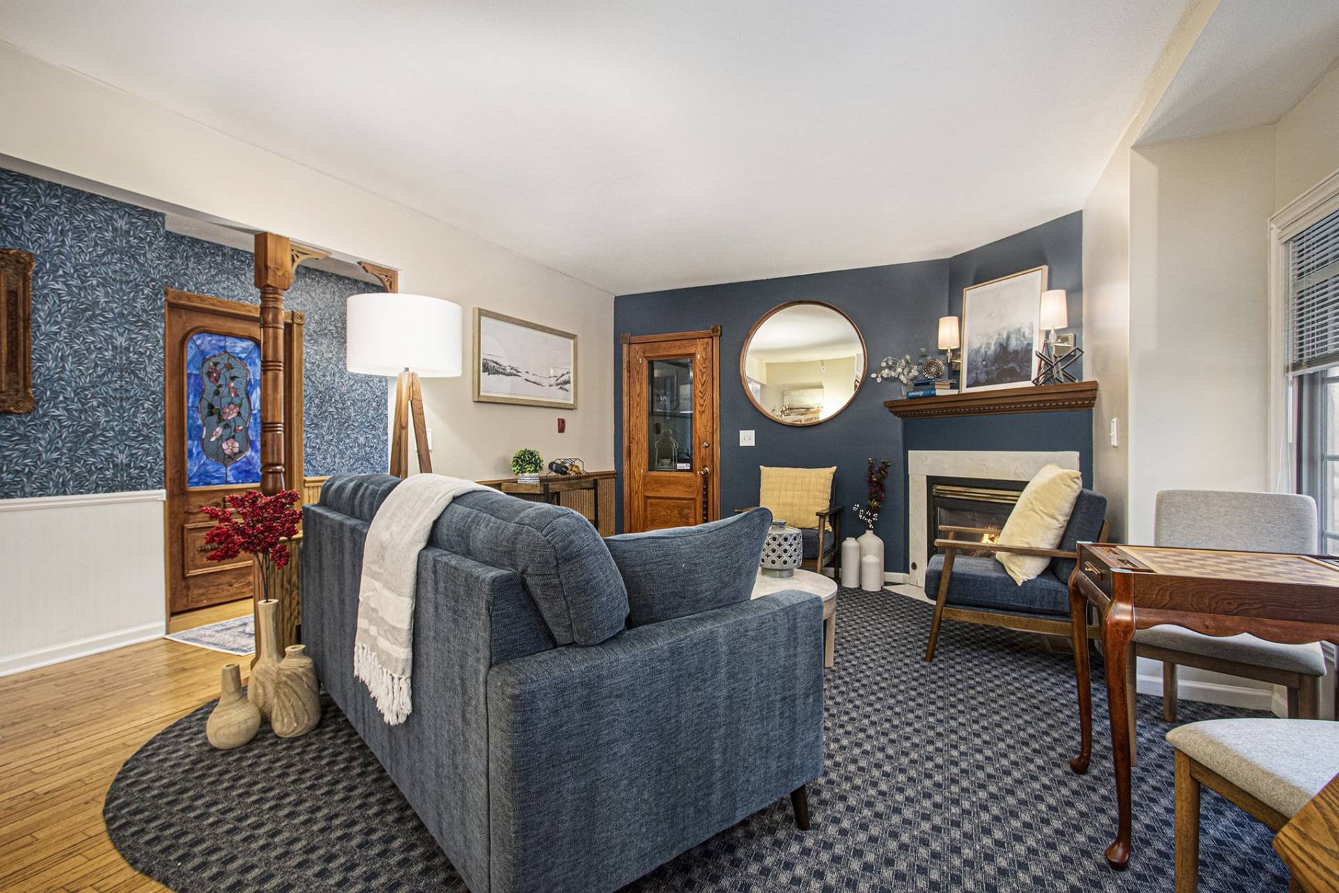 sitting room with blue couch, chairs, and a game table