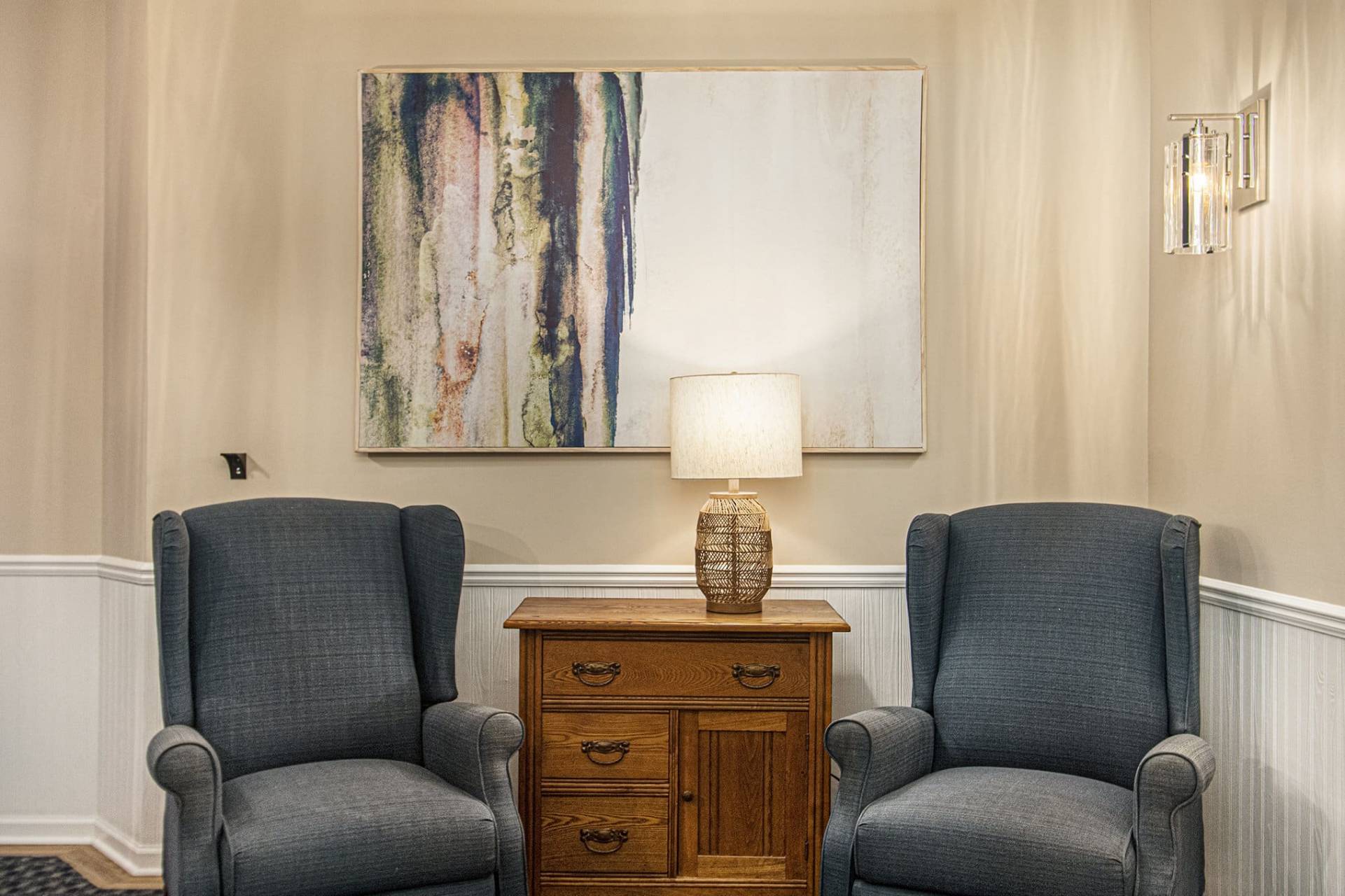 two upholstered chairs, lamp and large wall art