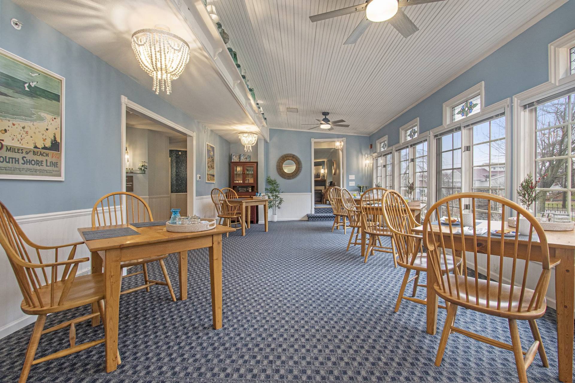 wood table and chairs in dining room with blue walls and blue carpet.