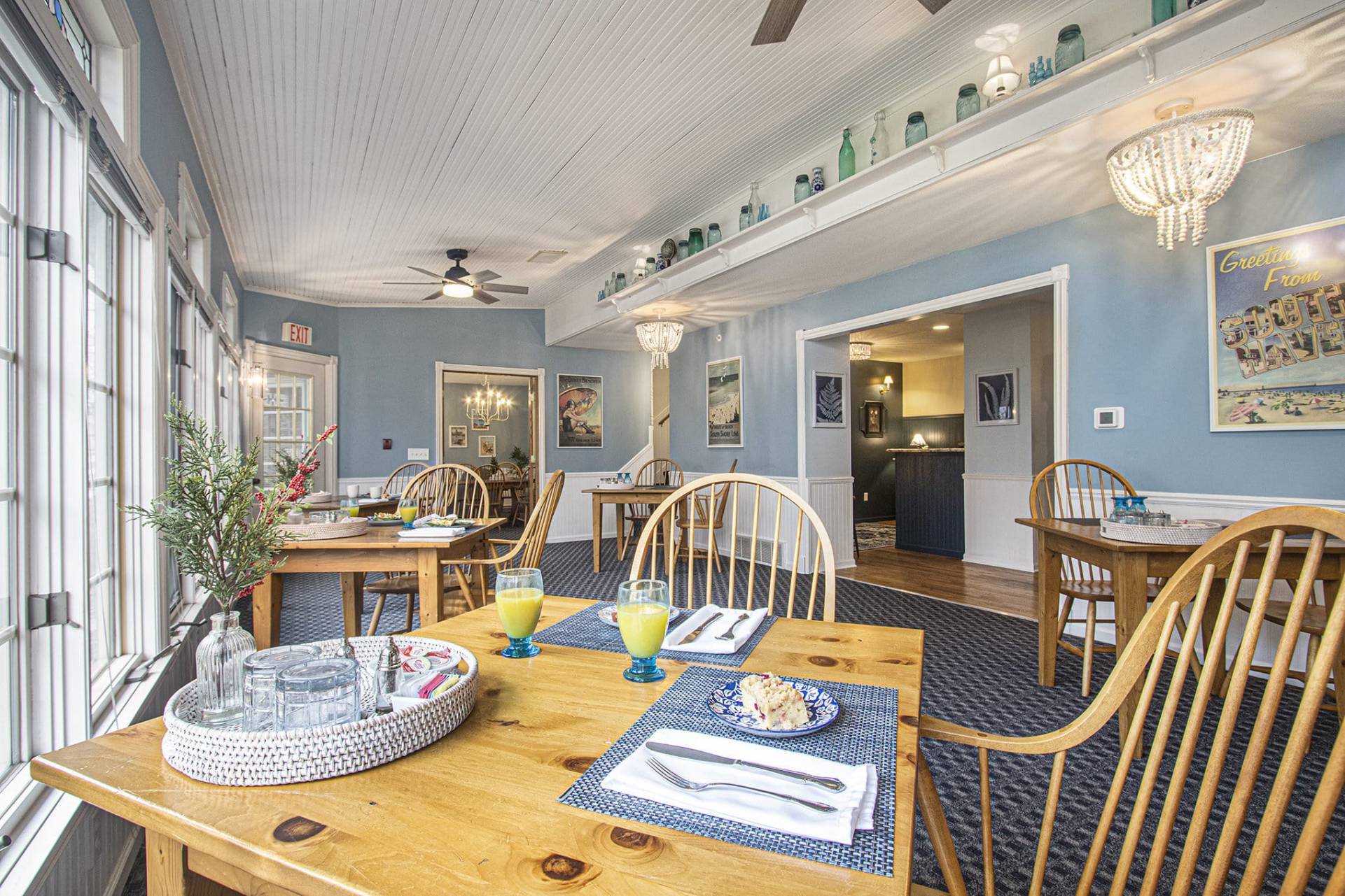 wood table and chairs in dining room with blue walls and blue carpet.